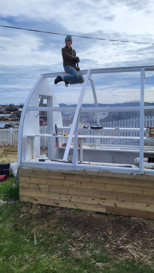 Janet sitting atop her greenhouse