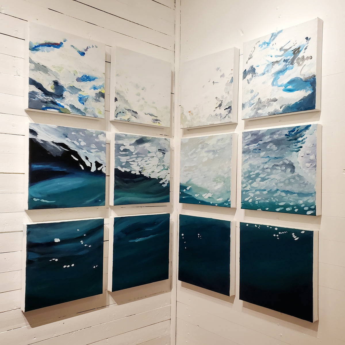 Grid of UNDERNEATH painting panels on white gallery wall at Norton's Cove Studio. © Janet Davis