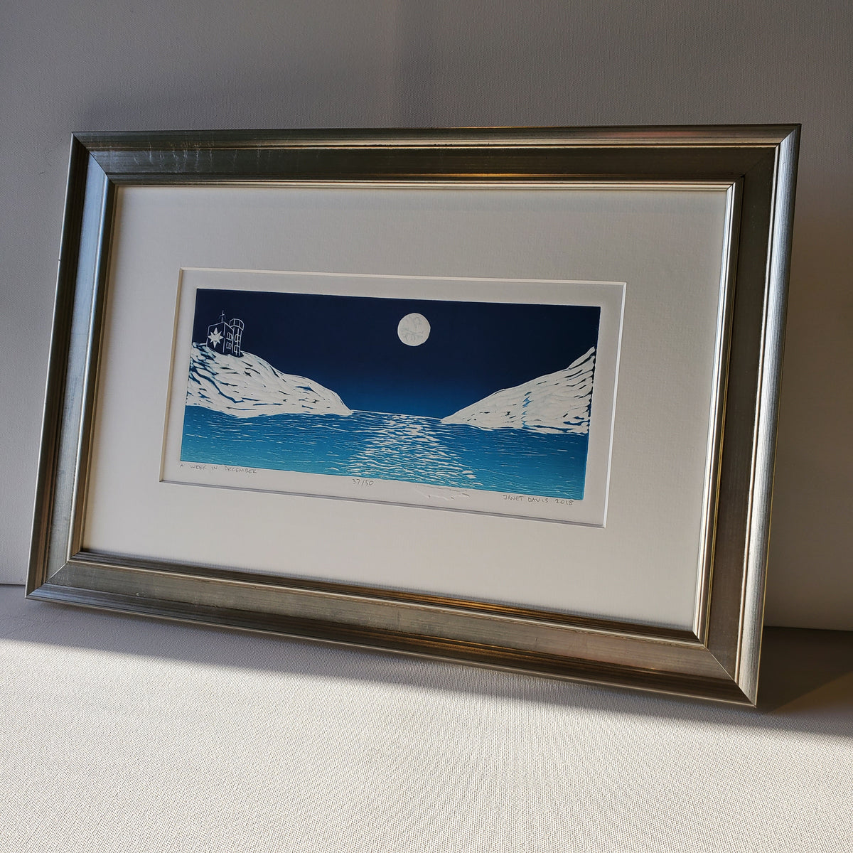A Week in December original limited edition linocut ©Janet Davis in a wooden frame with metallic finish
