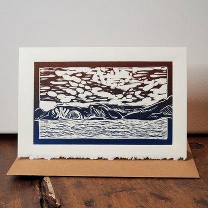Norton's Cove Card in the Norris Point of View design photographed on the wooden counter with a stretched canvas as a backdrop.