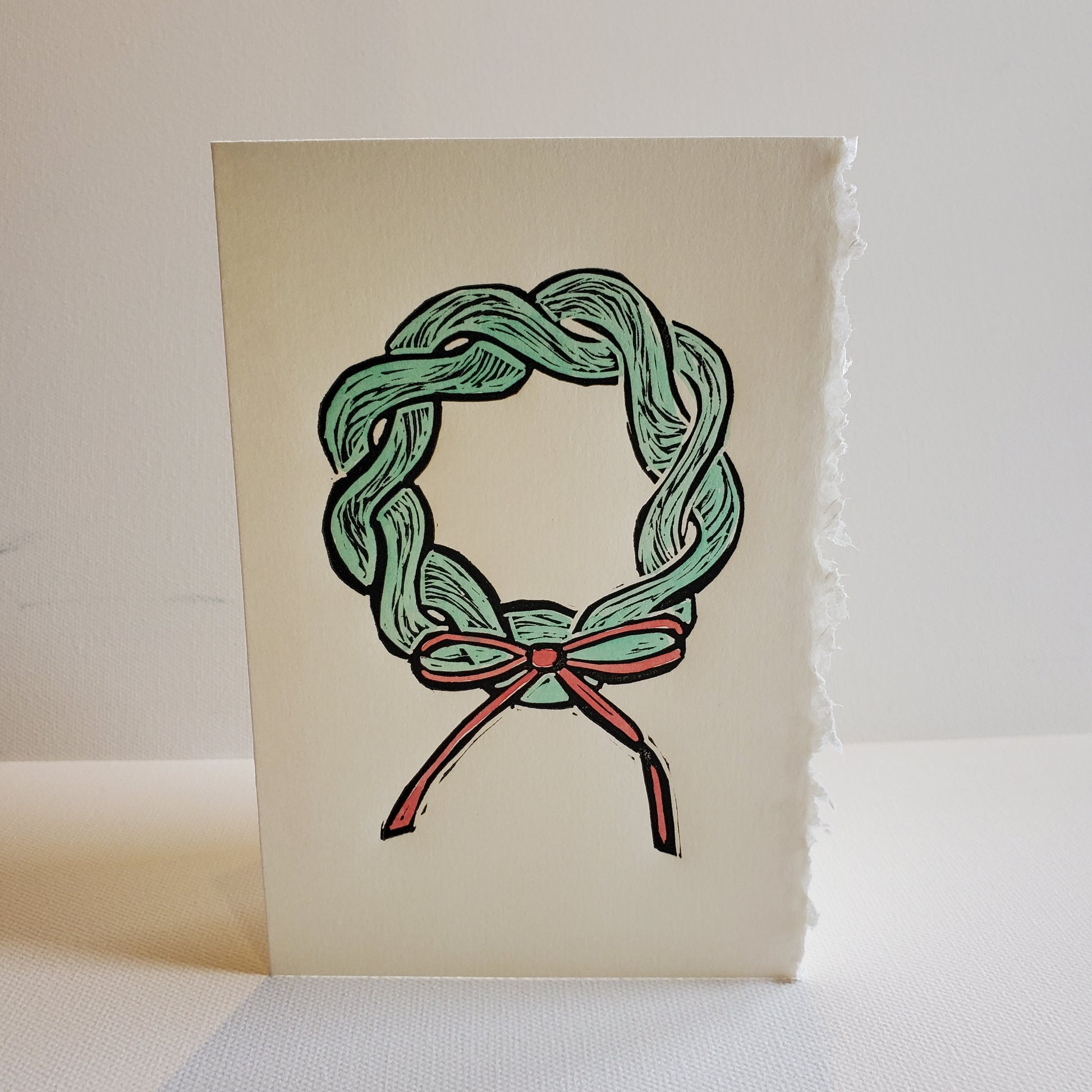 Green rope wreath with a red bow