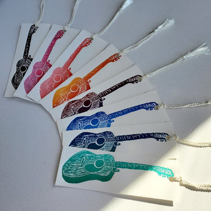 Fanned bookmarks in an assortment of available colours.  Yamiki acoustic guitar.
