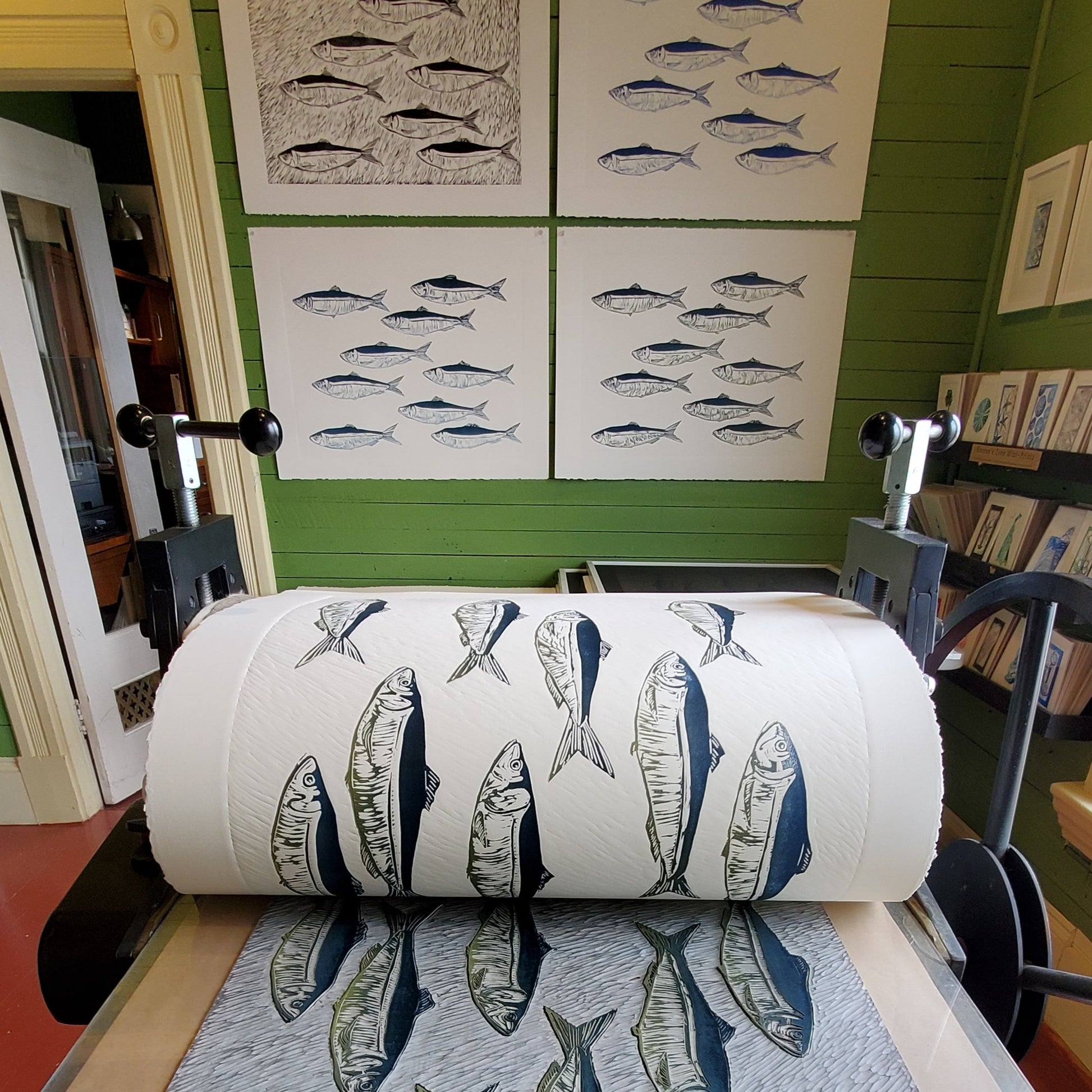 Editioning Smudge Herring: Just Keep Swimming at Norton's Cove Studio, August 2021.  Trial Proofs and BAT hanging on wall in background.  TP#1  upper left hand corner in b/w